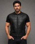 Front view of men's black genuine leather motorcycle riding vest featuring perforated ventilation panels, stand collar, zip-front closure, and athletic biker styling.