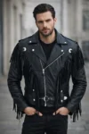 Man wearing a black fringe leather motorcycle jacket with tassel detailing, asymmetrical zipper, lapel collar, and adjustable waist belt